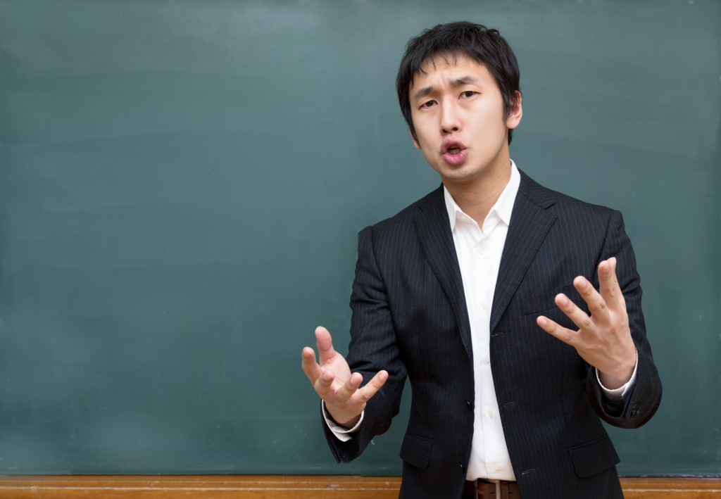 スーツ姿で演説している男性の画像