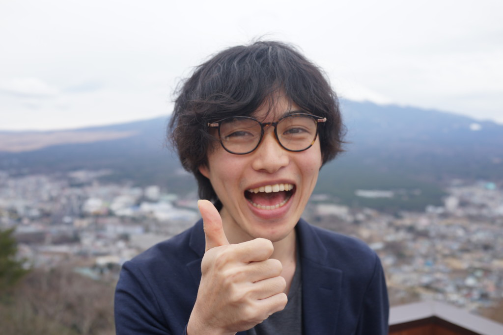 笑顔で親指を立てている男性の画像