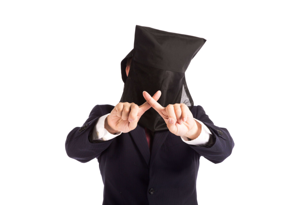 黒い頭巾をかぶって×サインしている男性の画像