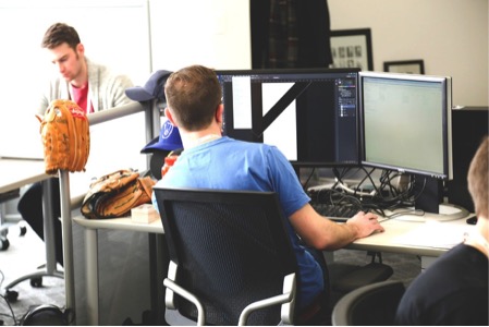 複数の画面を操作している男性の画像