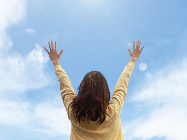 空に手を広げている女性