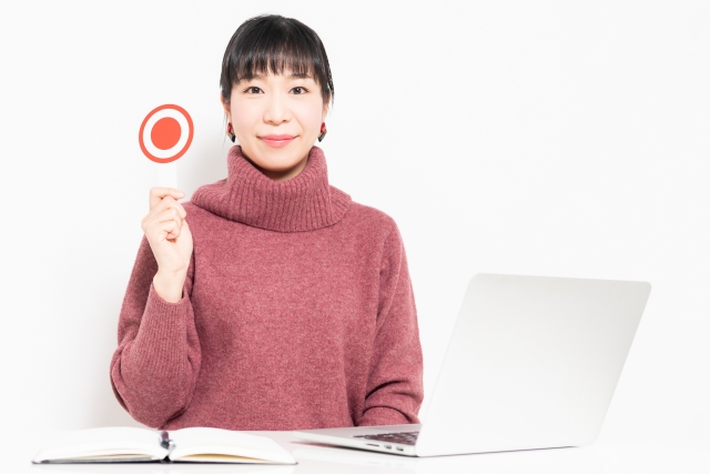 丸の札を持っている女性